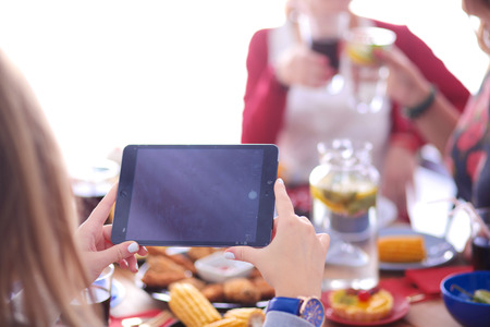 Top view of group of people having dinner together while sitting at wooden table. Food on the table. People eat fast food.の写真素材