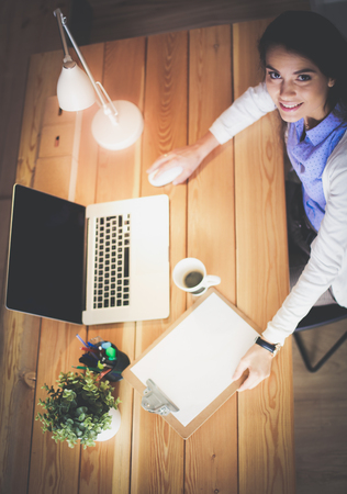 Portrait of relaxed young woman sitting at her desk holding cup of coffee. Business Woman. Workplaceの写真素材