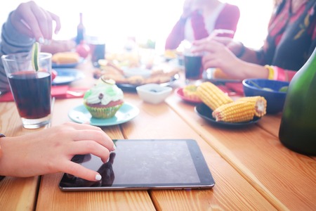 Top view of group of people having dinner together while sitting at wooden table. Food on the table. People eat fast foodの写真素材