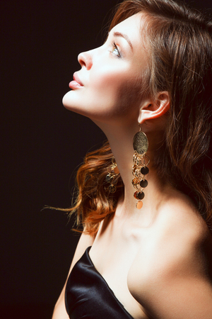 Portrait of beautiful young woman face. Isolated on dark backgroundの写真素材
