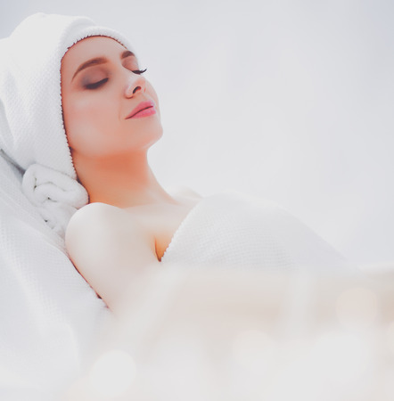 Young woman lying on a massage table,relaxing with eyes closedの写真素材