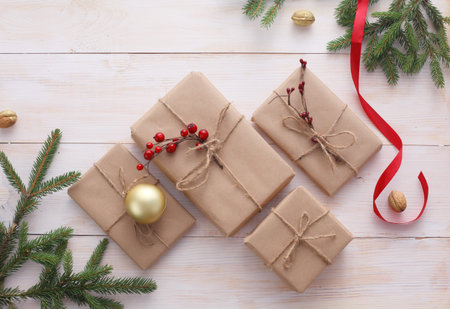 Christmas gift boxes and fir tree branch on wooden table, flat lay. ?hristmas background