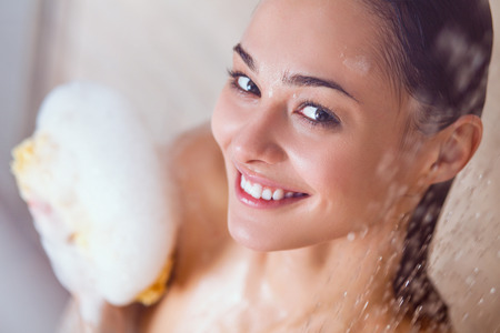 Young beautyful woman under shower in bathroom.の写真素材