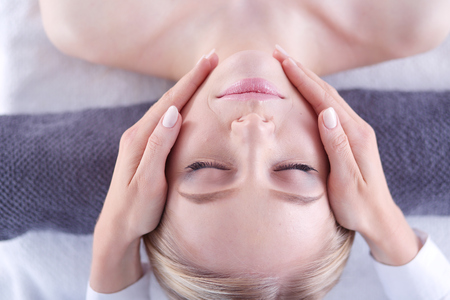 Young woman lying on a massage table,relaxing with eyes closed. Woman. Spa salonの写真素材