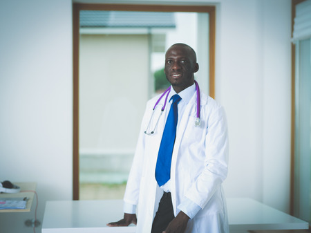 A smiling doctor with a folder in uniform indoors. Doctorsの写真素材
