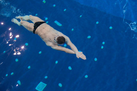 Male swimmer at the swimming pool. Underwater photo. Male swimmer.