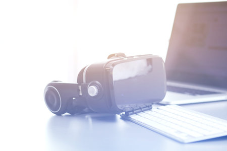 Virtual reality goggles on desk with laptop. business. 3d technologyの写真素材