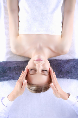 Young woman lying on a massage table,relaxing with eyes closed. Woman. Spa salonの写真素材