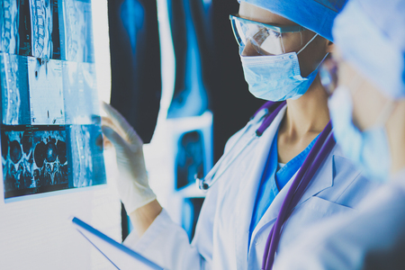 Two female women medical doctors looking at x-rays in a hospitalの写真素材