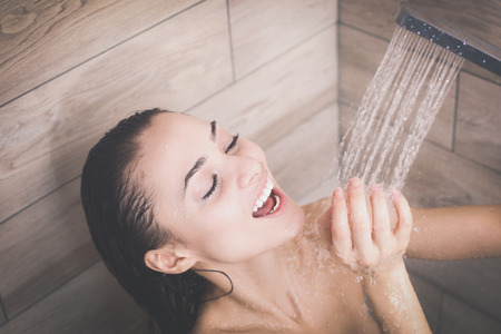 Young beautyful woman under shower in bathroom.の写真素材