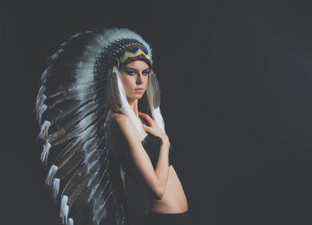 Beautiful woman in native american costume with feathers. Beautiful woman
