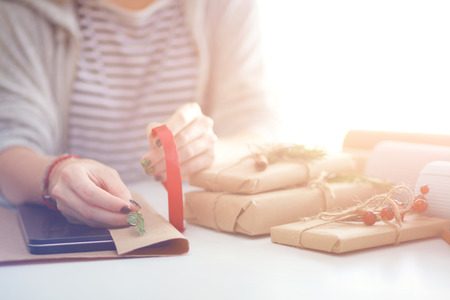 Hands of woman decorating christmas gift box. Hands of womanの写真素材