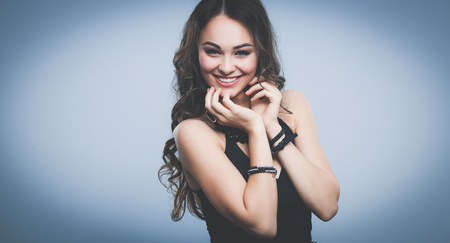 Portrait of a beautiful woman with necklace, isolated on grey backgroundの写真素材
