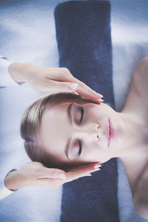 Young woman lying on a massage table,relaxing with eyes closed. Woman. Spa salonの写真素材