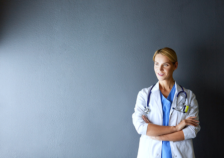 Portrait of young woman doctor with white coat standing in hospital.の写真素材