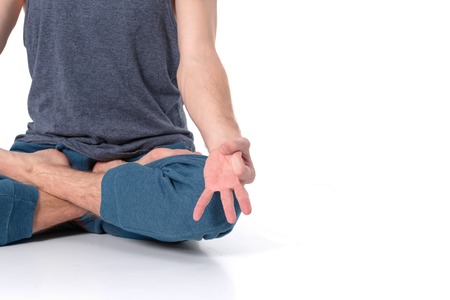 Adult man with naked torso doing exercise on white background.の写真素材