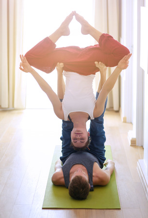 Young athletic couple practicing acroyoga. Balancing in pairの写真素材