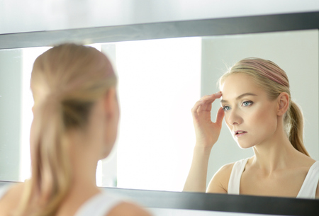 face of young beautiful healthy woman and reflection in the mirrorの写真素材