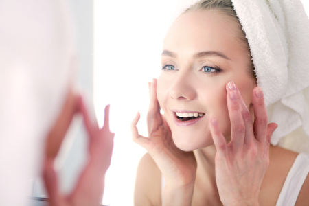 face of young beautiful healthy woman and reflection in the mirrorの写真素材
