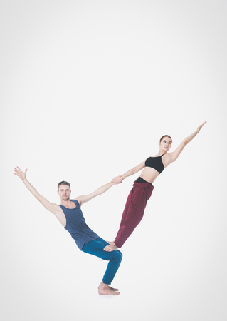 Young athletic couple practicing acroyoga. Balancing in pairの写真素材