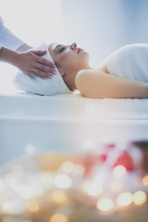 Young woman lying on a massage table,relaxing with eyes closed. Woman. Spa salonの写真素材