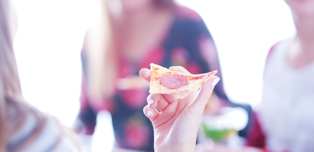 Top view of group of people having dinner together while sitting at wooden table. Food on the table. People eat fast food.の写真素材