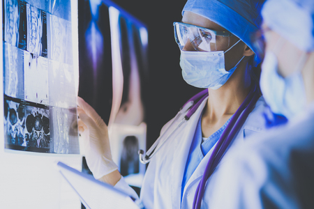Two female women medical doctors looking at x-rays in a hospital.の写真素材