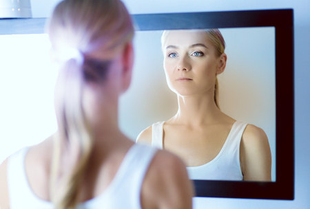 The beautiful young girl with a clean fresh skin touches with a hand a cheekの写真素材
