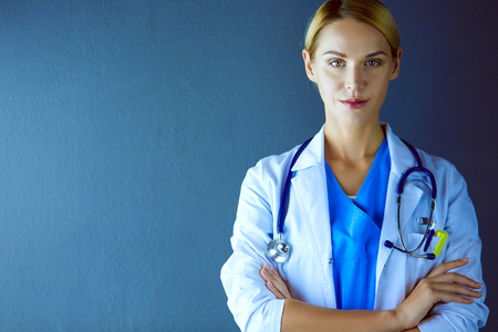 Portrait of young woman doctor with white coat standing in hospital.の写真素材