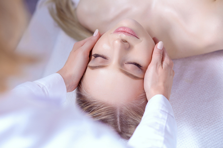 Young woman lying on a massage table,relaxing with eyes closed.の写真素材