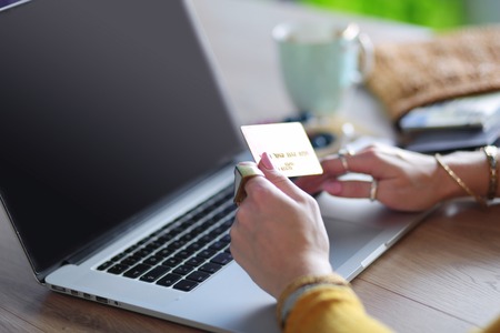 Young woman holding credit card and using laptop computer. Online shopping conceptの写真素材