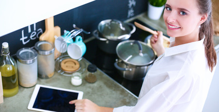 Woman baking at home following recipe on a tabletの写真素材