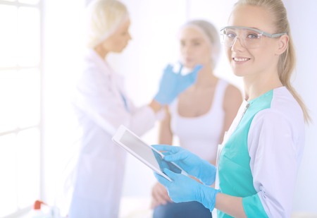 Beautiful woman face near doctor with syringeの写真素材