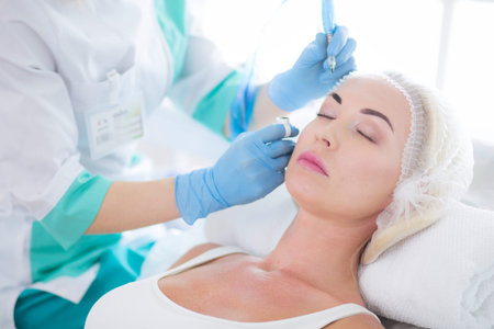 Permanent makeup for eyebrows. Closeup of beautiful woman with thick brows in beauty salon