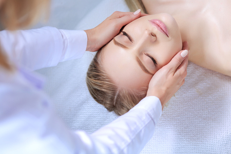 Young woman lying on a massage table,relaxing with eyes closed. Woman. Spa salonの写真素材
