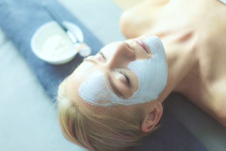 Face mask.Beautiful young girl at spa ,cosmetician woman applying facial mask.の写真素材