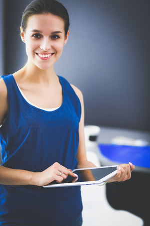Attractive woman working on a tablet in a home officeの写真素材