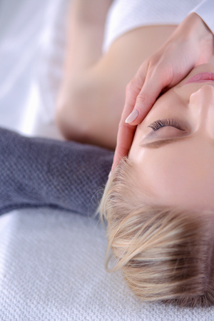 Young woman lying on a massage table,relaxing with eyes closed. Woman. Spa salonの写真素材