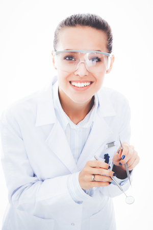 Beautiful female dentist doctor holding and showing a toothbrush isolated on a white background. Dentist doctorの写真素材