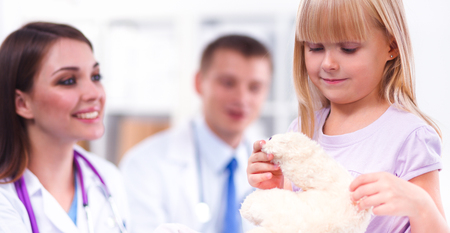 Female doctor examining child with stethoscope at surgeryの写真素材