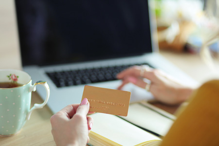 Young woman holding credit card and using laptop computer. Online shopping conceptの写真素材