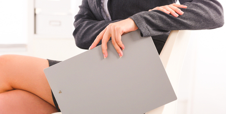 Young happy businesswoman in office holding a folderの写真素材