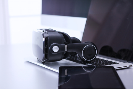 Virtual reality goggles on desk with laptop. business. 3d technologyの写真素材