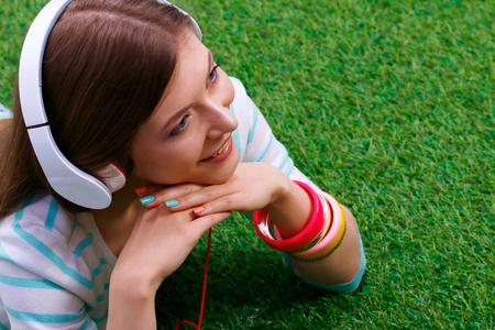 Young woman sitting on green grass . Portreit young womanの写真素材