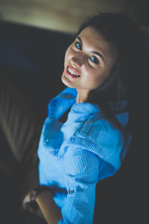 Portrait of happy young woman sitting on sofa. young womanの写真素材