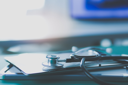 Medical equipment: blue stethoscope and tablet on white background.の写真素材