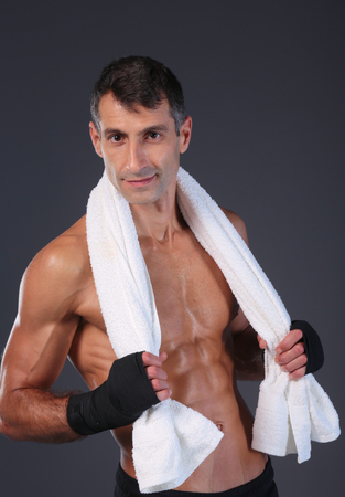 Strong athletic man standing on black background.の写真素材