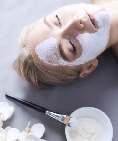 Face mask.Beautiful young girl at spa ,cosmetician woman applying facial maskの写真素材
