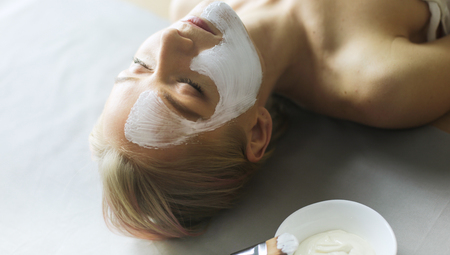 Face mask.Beautiful young girl at spa ,cosmetician woman applying facial mask.の写真素材