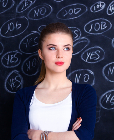Thinking young woman with yes or no choice on gray backgroundの写真素材